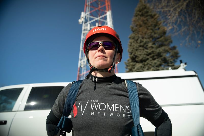 woman standing in front of van and cell tower